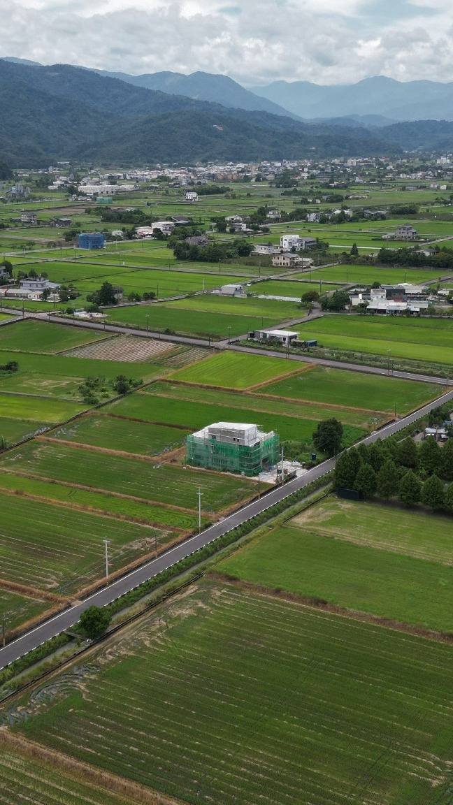 Aerial view of demarcated residential plots among green fields